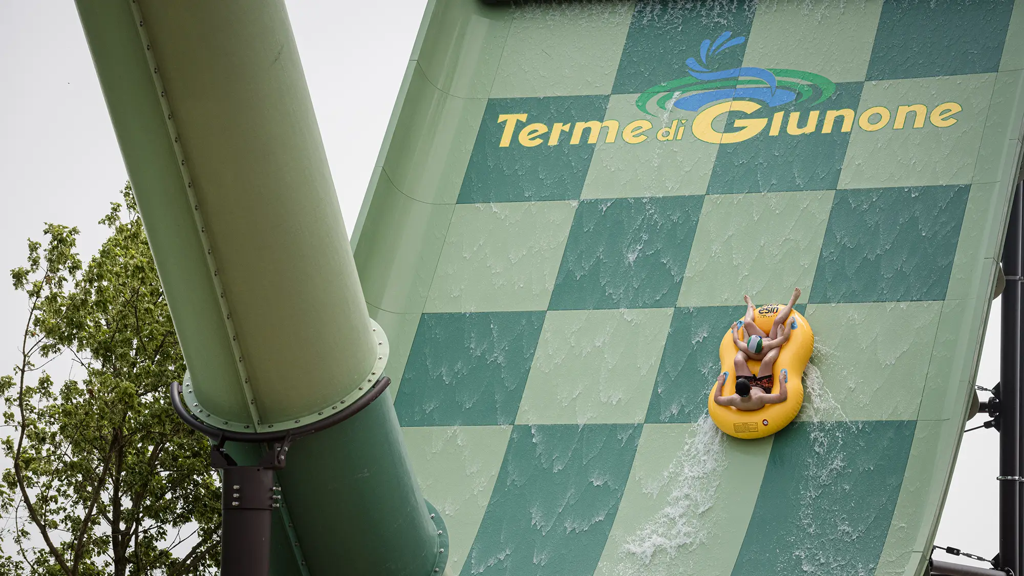 Gommone con ragazzi su acquascivolo che riporta il logo Terme di Giunone