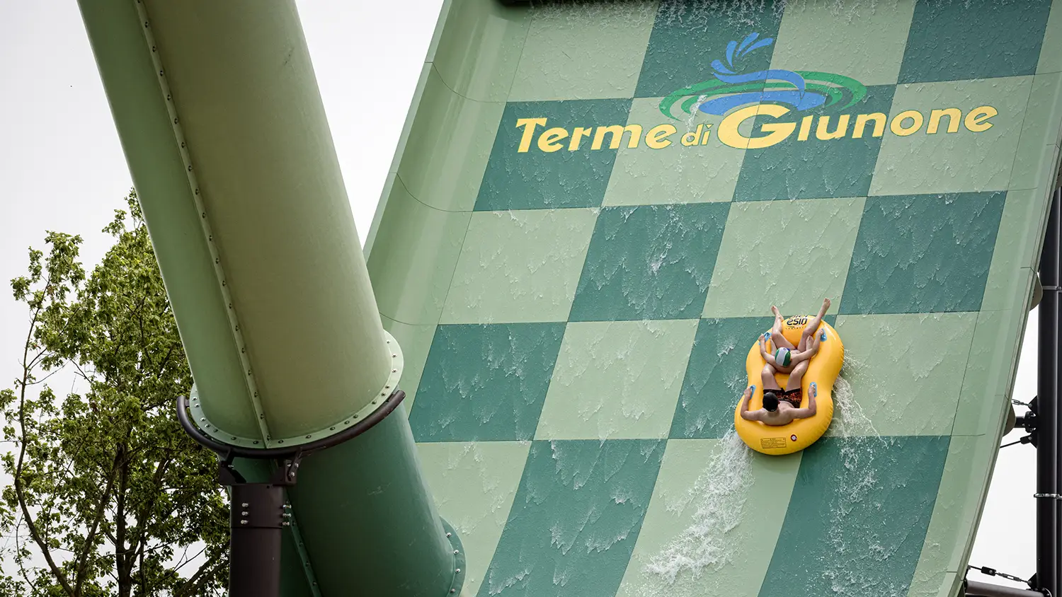 Scivolo ripido con gommone e ragazzi che si divertono