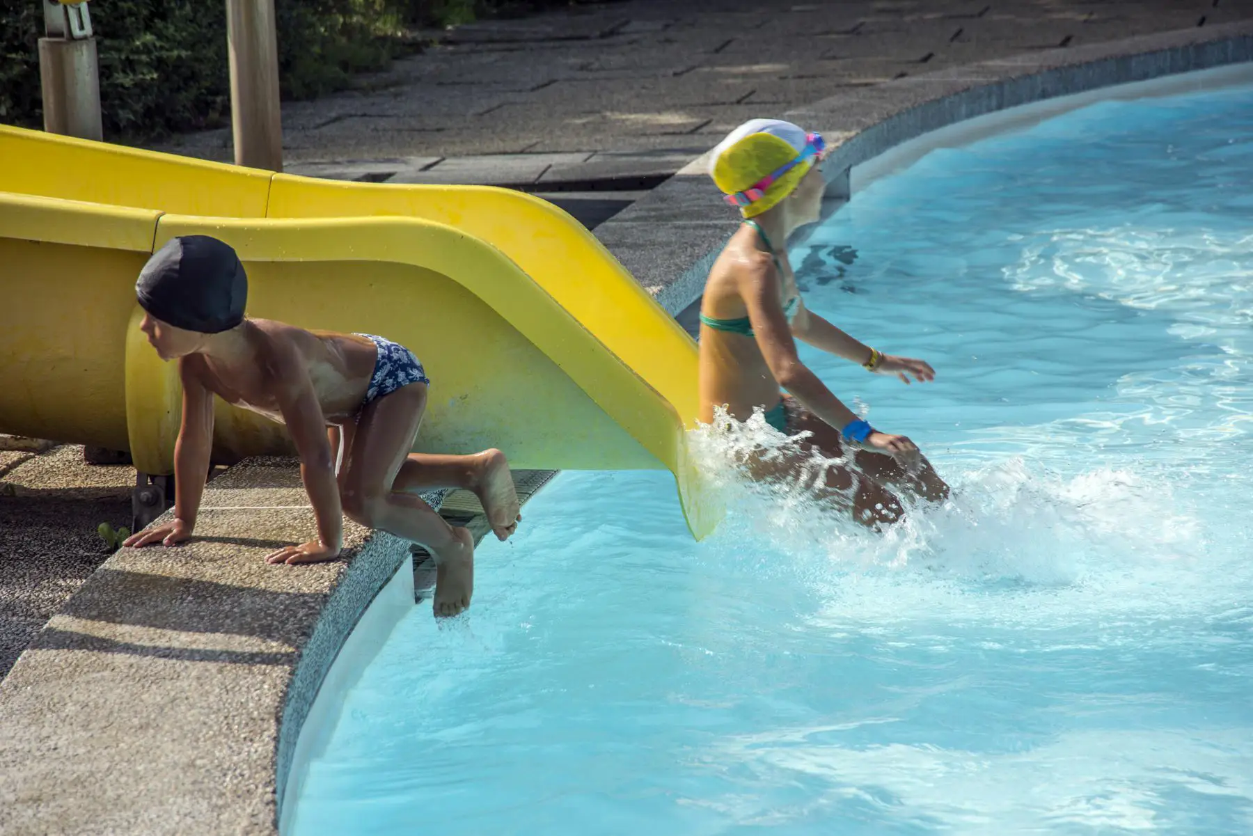 Bambino che dallo scivolo finisce in piscina