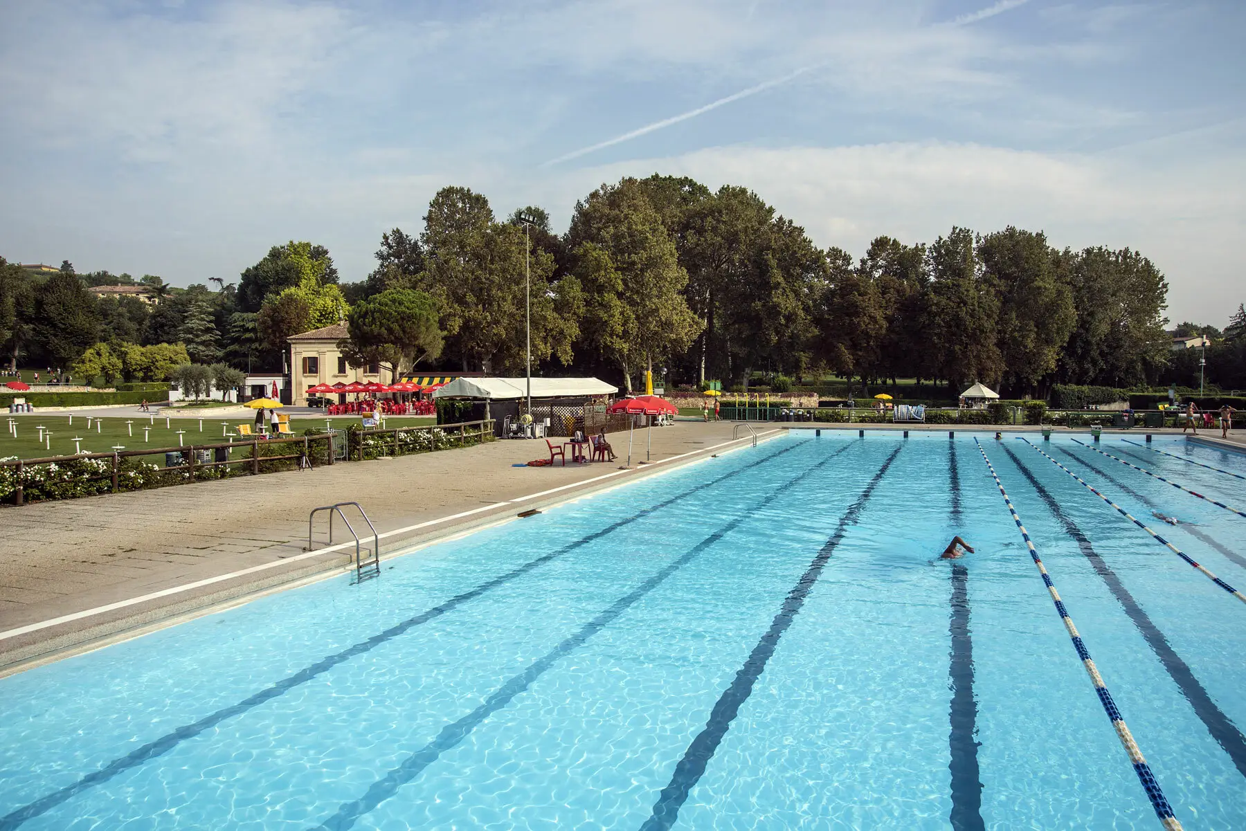 Piscina olimpionica con angolo bar in lontananza